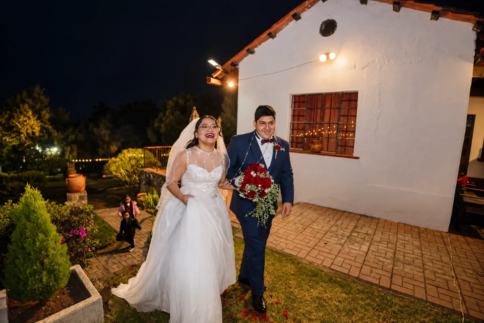 La pareja camina por un jardín iluminado
